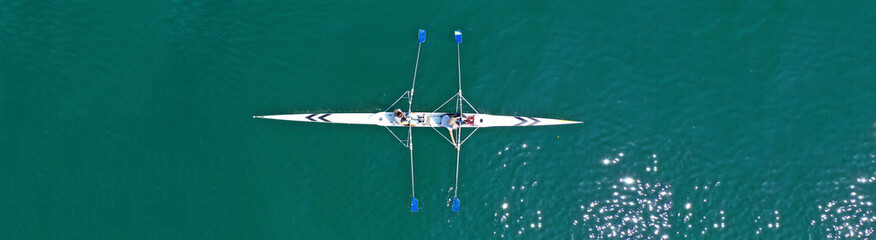 Aerial drone top panoramic view of sport canoe rowing synchronous athletes competing in tropical...