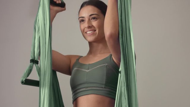 Female techer begin her class and jump into an aerial yoga hammock