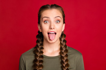 Close up photo of pretty teen model lady playing with classmate sticking tongue out mouth wear casual pullover isolated red color background © deagreez