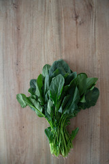 bunch of fresh spinach on wooden table. space for text 