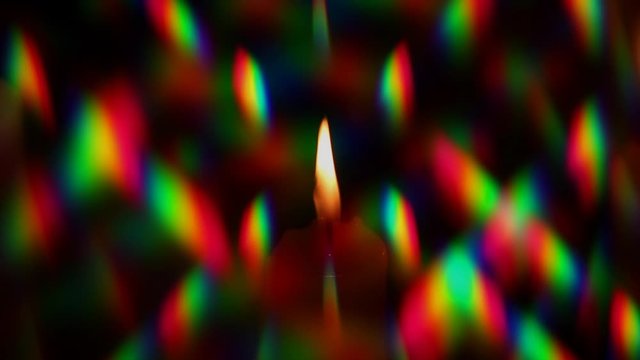 Flame of a candle surrounded by a halo of multi-colored glares, was filmed through two crossed diffraction gratings. Diffraction pattern of light from a candle, including several diffraction orders