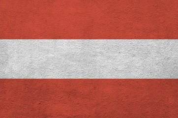 Austria flag depicted in bright paint colors on old relief plastering wall. Textured banner on...