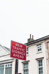 Fototapeta premium Red street sign with white letters saying ,,new trafic signaks ahead,,