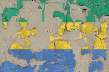 Gabon flag depicted in paint colors on old obsolete messy concrete wall closeup. Textured banner on...