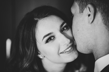 Fototapeta premium Romantic black and white photo. Man hugs a happy woman. Young couple in love on Valentine's day. International Women's Day. Close up.