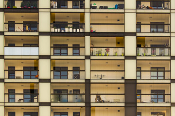Glass balcony exterior. Condominium neighborhood. Difference between people. Barbell, greens, bicycle, sofa.   