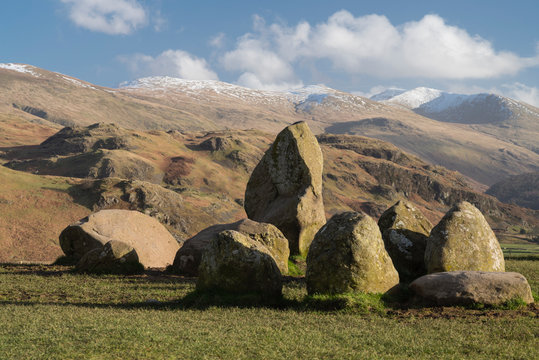 Cumbria, England, UK: part of the Castlerigg neolithic stone circle on a fresh bright day with snow on the peaks behind.   Erected around 3000BC.