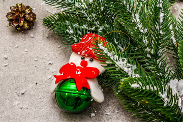 Christmas decoration background. Evergreen fir tree branch, cones, snowman and artificial snow....