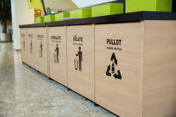 Trash bins in public area next to fast food restaurant, separating different kinds of garbage....