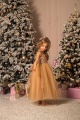 Close up. A beautiful girlie in a golden elegant dress exquisitely dances in a festively decorated room.