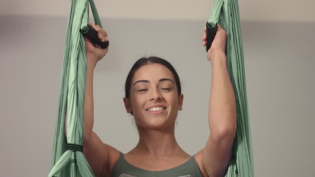tilted plan of female aerial yoga teacher begins her class and jump into a hammock