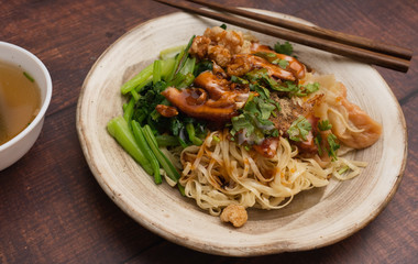 egg noodle with charcoal grill marinated pork and clean soup.