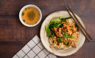 Top view egg noodle with charcoal grill marinated pork and clean soup.