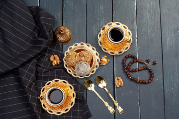 Nut balls dessert served with coffee on dark wooden table, top view