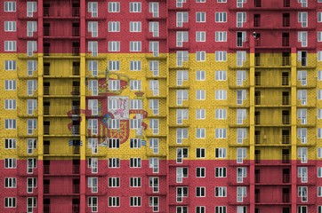Spain flag depicted in paint colors on multi-storey residental building under construction....