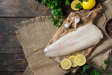 Whitefish lightly salted on a wooden Board on a brown wooden table. Whole fillet of fish whitefish...
