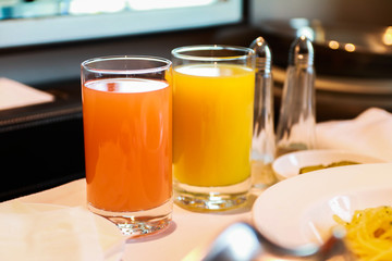 Fresh vegetable and fruit red and yellow juices on a transparent glass