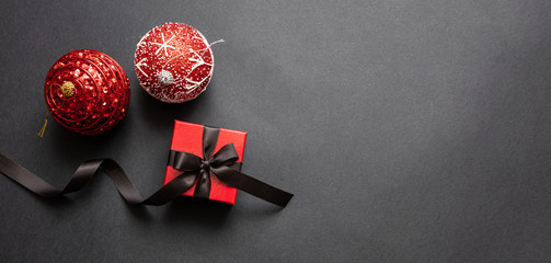 Christmas present and red xmas balls against black background, Black Friday Christmas concept.
