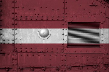 Latvia flag depicted on side part of military armored tank closeup. Army forces conceptual...
