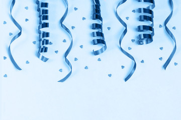 Blue party streamers and hearts on light background. Flat lay. The concept of celebrations, the Day of St. Valentine, wedding, holiday, birthday, etc.