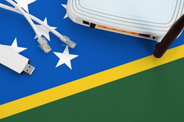 Solomon Islands flag depicted on table with internet rj45 cable, wireless usb wifi adapter and...