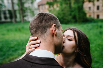 Portrait of young wedding couple kissing at nature. Newlyweds.