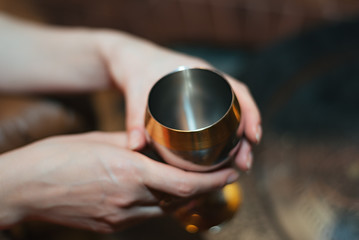 Fototapeta na wymiar Close-up image of a silver glass in female hands