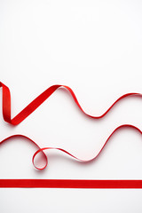 top view of red curled ribbons on white with copy space