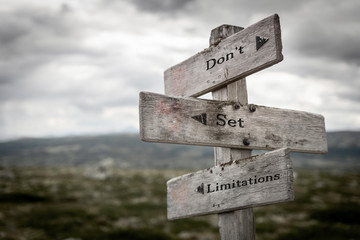 Don't set limitations text on wooden rustic signpost outdoors in nature/mountain scenery....