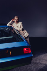 attractive and stylish woman in suit standing near retro car