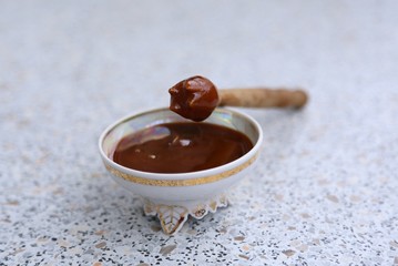 Spoon of wood for honey and honey in a socket on the table