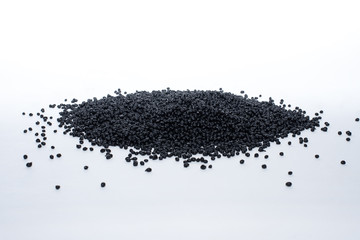 Granules of black termoplastic elastomer on a white background