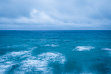 Fototapeta premium cloudy stormy sky leaving for horizon above a blue surface of the sea