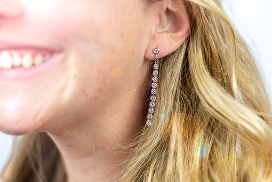 diamond drop earrings on happy smiling woman
