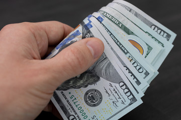 money in hand. man holds in his hand wad of American dollars.