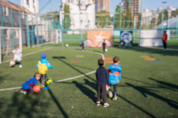 Boys at a football training. The concept of a healthy lifestyle and sport. Blurry