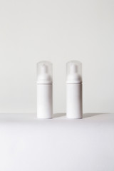 two small white spray bottles for cosmetics