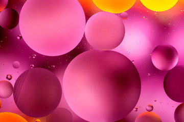 bright oily drops in water with colorful background, close-up 