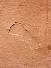 old painted plaster wall with peeling terracotta stucco