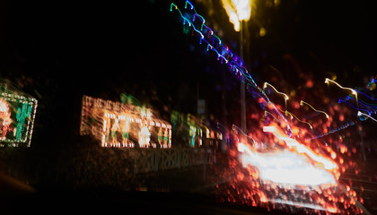 Fototapeta na wymiar Abstract painterly rain drops on a car window with vibrant city and street lights out of focus in the background. Tired and drunk driving in wet and rainy conditions. safe driving.