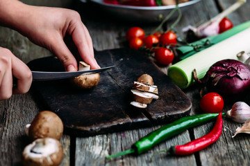 Female hands cut vegetables on the board. Cooking vegetarian food.