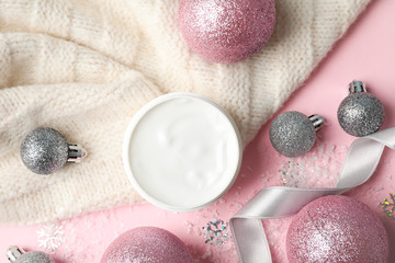 Obraz na płótnie Canvas Jar of winter cream for skin, warm sweater on pink background, space for text. Top view