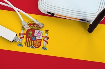 Spain flag depicted on table with internet rj45 cable, wireless usb wifi adapter and router....