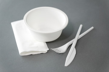 eating, recycling and ecology concept - white disposable plastic plate with fork, knife and paper...
