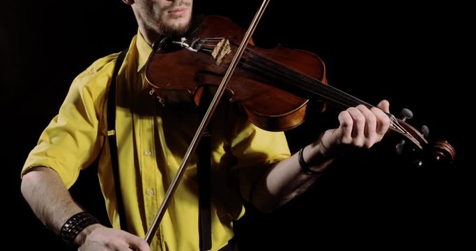 Man professional violinist plays alt or violin on black background, instrument closeup. Guy musician playing solo on alt. Elegant person performs classical composition on fiddlestick instrument.