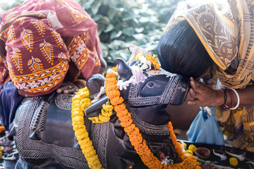 an Indian woman worships the sacred bull Nandi.