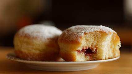 Delicious sugar coated doughnuts filled with strawberry jam on a plate