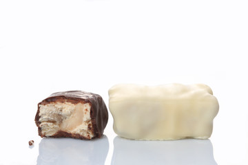 bitten brown and white chocolate candies isolated on white background with copy space for your text