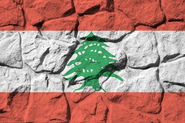 Lebanon flag depicted in paint colors on old stone wall closeup. Textured banner on rock wall...
