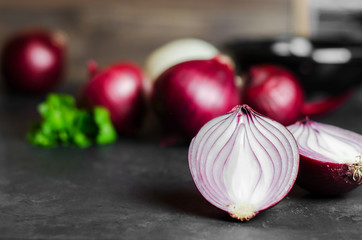 Cut red onion on dark background. Selective focus. Copy space
